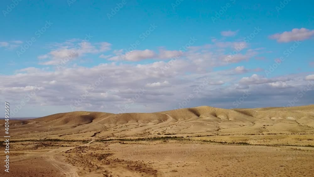 Landing from the sky with fluffy clouds to hills in desert Negev Landing from the sky with fluffy clouds to hills in desert Negev