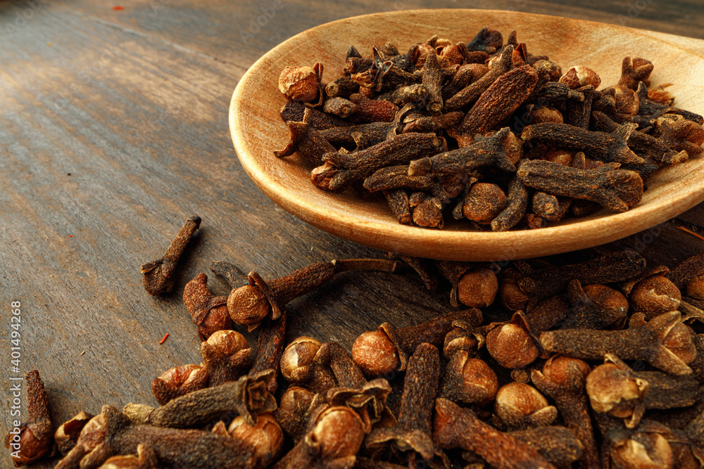 Heap of clove spice on wooden table Heap of clove spice on wooden table