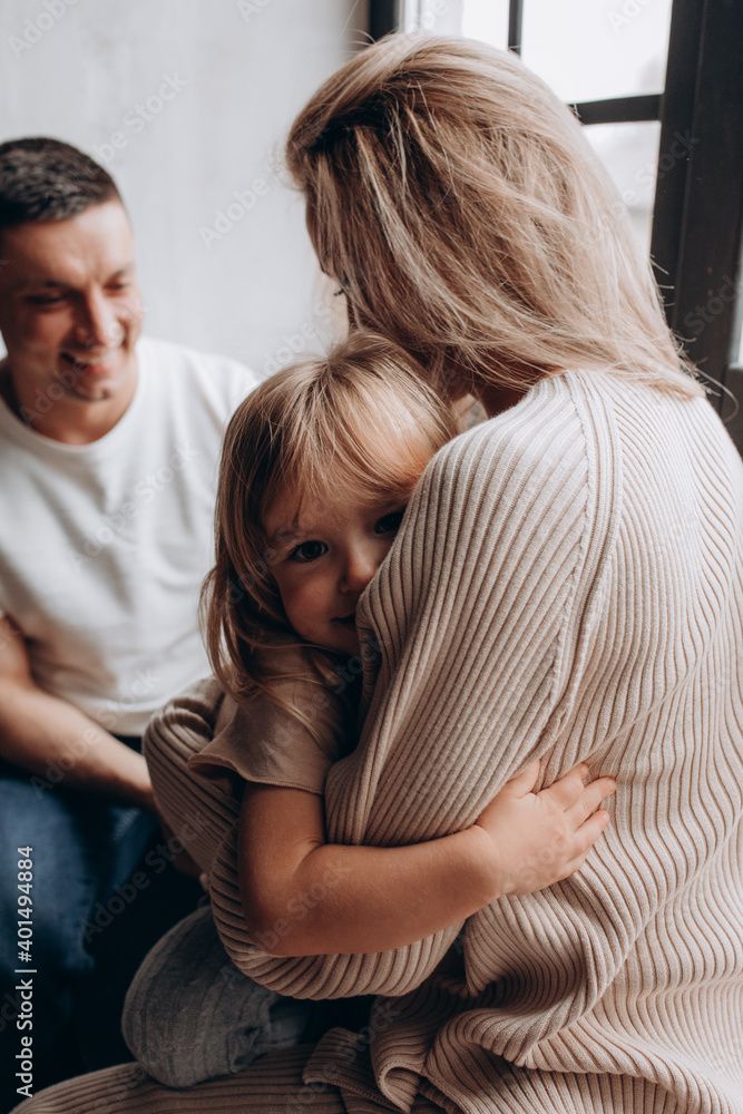Photoshoot of a happy young family. Dad, mom and daughter. Studio photography. Photoshoot of a happy young family. Dad, mom and daughter. Studio photography.