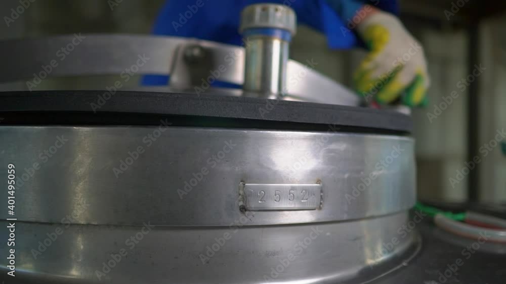 a worker opens a tank in production a worker opens a tank in production