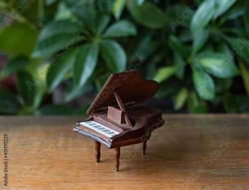 Miniature piano - doll house accessory, furniture - small toy on a wooden table