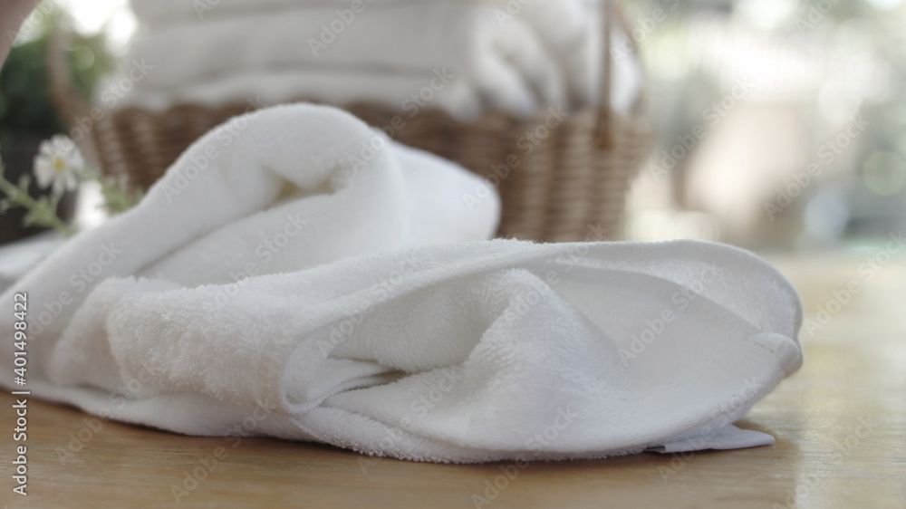 Towel placed on basket, white table top, bottle of liquid soap, spa set for bathing in the bathroom, copy space, bathroom window. Towel placed on basket, white table top, bottle of liquid soap, spa set for bathing in the bathroom, copy space, bathroom window.