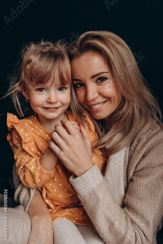 Young mother with her little daughter. Maternal love for a child. Studio photography.