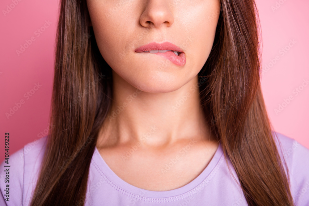 Close-up photo portrait of woman biting lower lip isolated on pastel pink colored background Close-up photo portrait of woman biting lower lip isolated on pastel pink colored background
