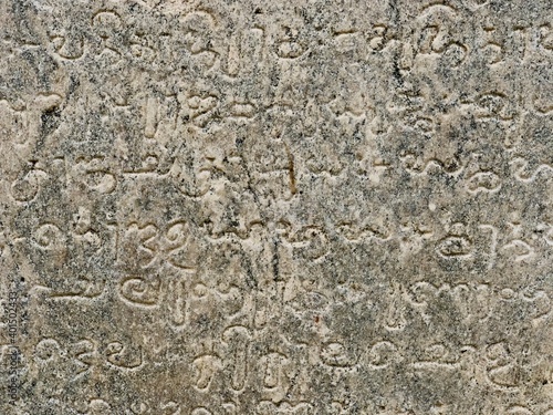Inscriptions on the ancient temple stone walls. Ancient stone carving. Old stone wall texture. Tamil inscriptions in historical temple walls. Carved inscription in Kanchi Kailasanathar temple.