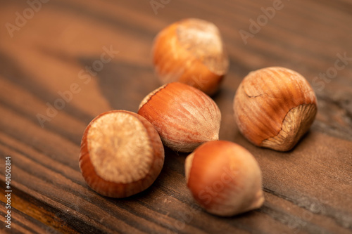 A few hazelnuts scattered on the wooden surface. Close-up, selective focus.