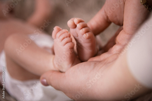 Baby feet in mother hands. Mom and her Child. Happy Family concept. Beautiful conceptual image of Maternity