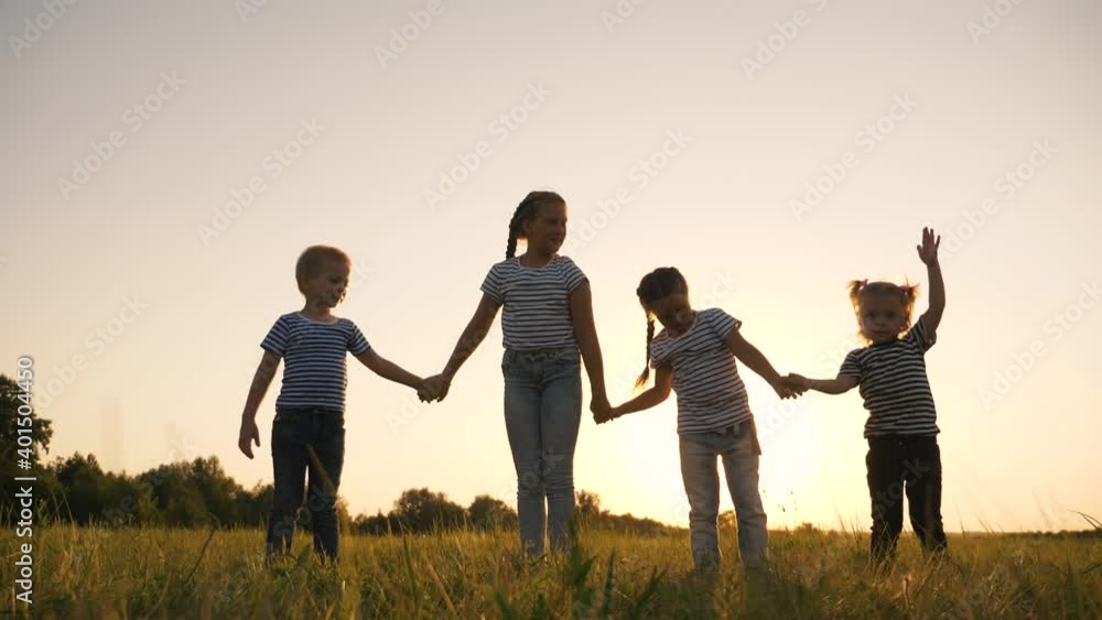 Happy family silhouette in the park. A crowd of children raise their hands up. Family childhood dream concept. The kids raised their hands up. Happy kids teamwork in the park. Happy family silhouette in the park. A crowd of children raise their hands up. Family childhood dream concept. The kids raised their hands up. Happy kids teamwork in the park.