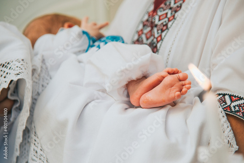 Fotografía Godfather holds baby in church at sacrament of baptism.