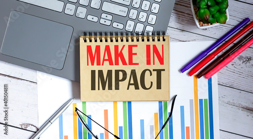 MAKE IN IMPACT text in notepad with a business objects and chart and laptop photo