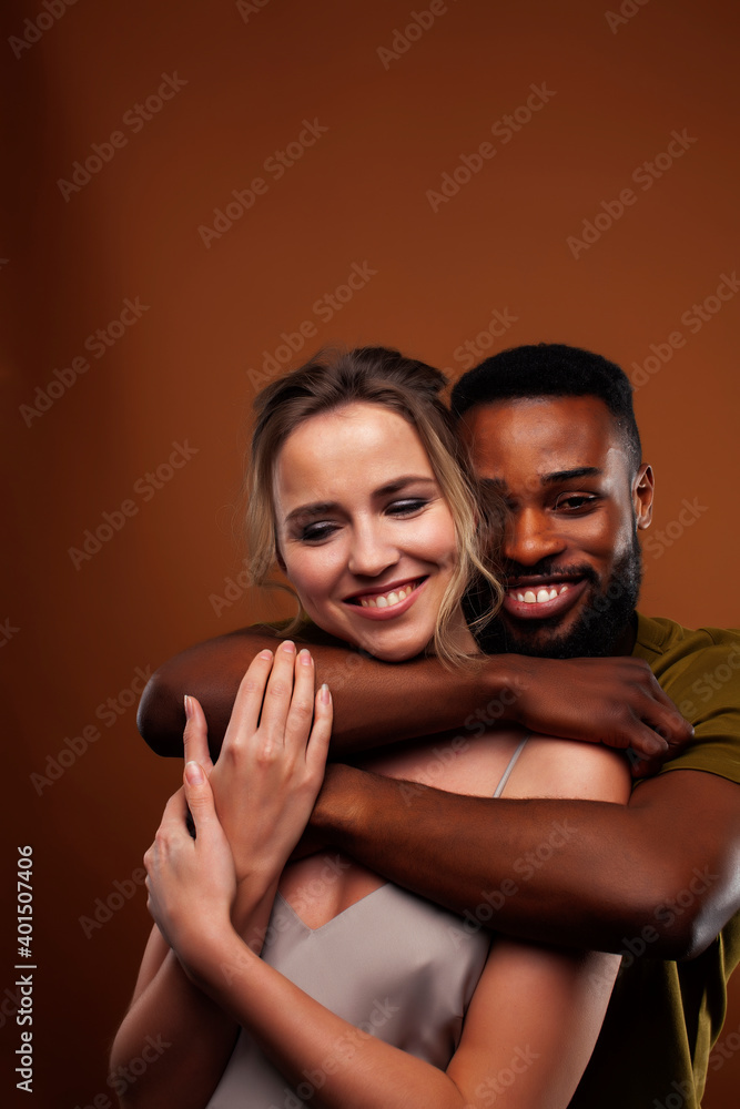 oung pretty couple diverse races together posing sensitive on brown background, lifestyle people concept oung pretty couple diverse races together posing sensitive on brown background, lifestyle people concept