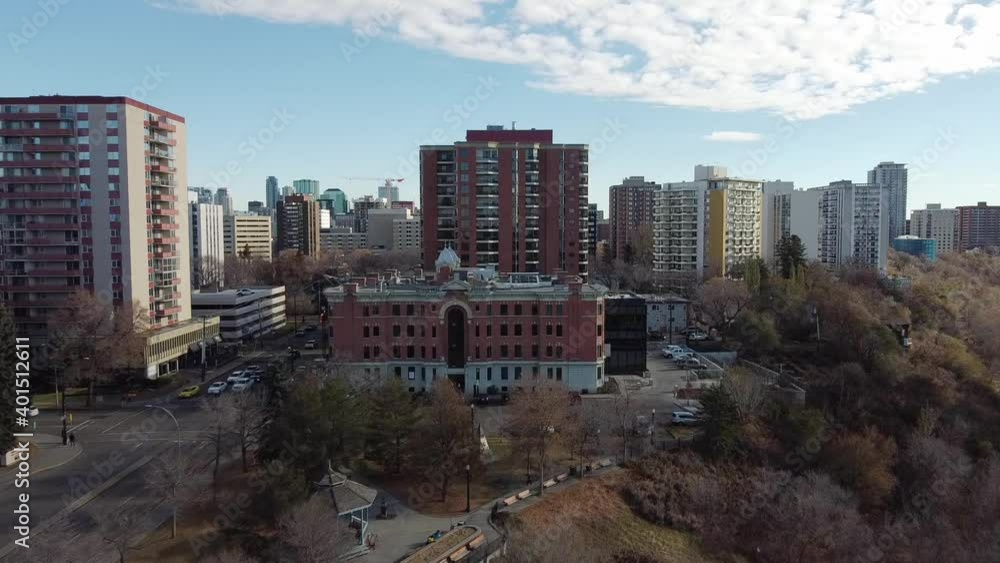 aerial fly over cliffs edge forest park by a vintage historic commercial building next to densily populated high rise condominiums apartment buildings hotels, hospital and offices in Edmonton Canada aerial fly over cliffs edge forest park by a vintage historic commercial building next to densily populated high rise condominiums apartment buildings hotels, hospital and offices in Edmonton Canada