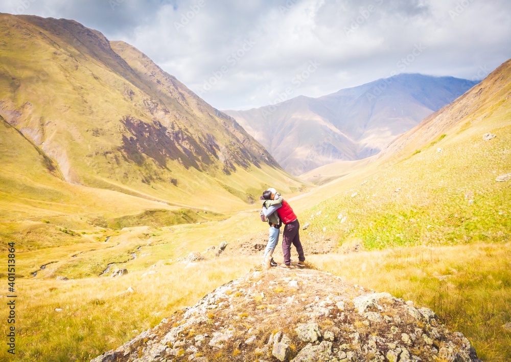 Couples strong hug in scenic locationwith beautful panoramic view of Kazbegi mountains