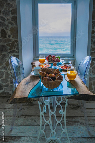 Fototapeta Naklejka Na Ścianę i Meble -  breakfast with a view over the ocean from the window,Cefalu, medieval village of Sicily island, Province of Palermo, Italy. Europe