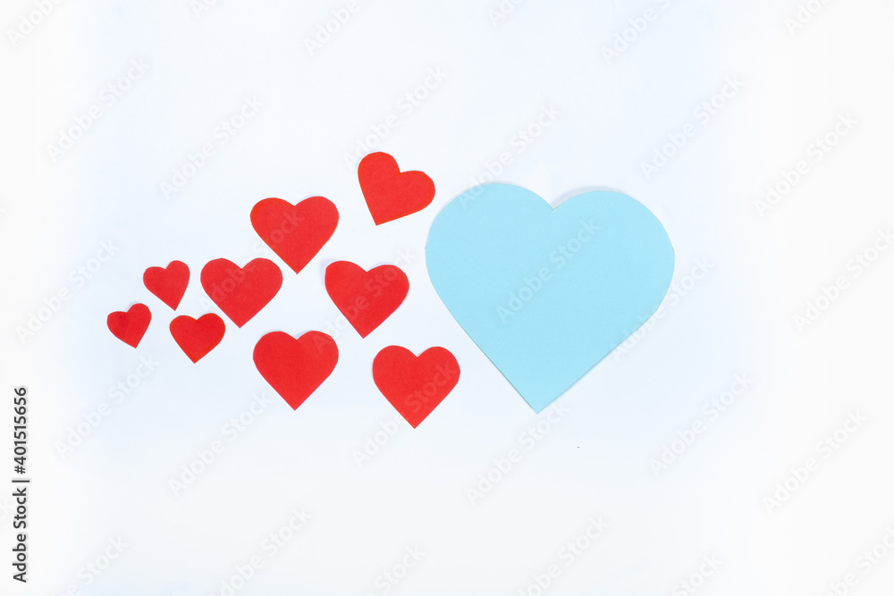Red small hearts and one big blue on a white background. Top view. Valentine's day concept. Red small hearts and one big blue on a white background. Top view. Valentine's day concept.