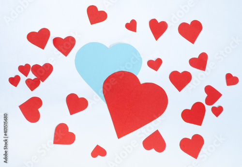 Hearts cut from paper in different colors and sizes. White background. Top view.