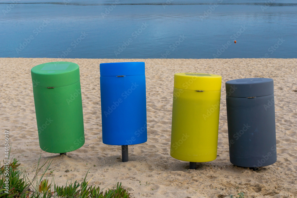 colorful recycling bins on a sandy beach colorful recycling bins on a sandy beach