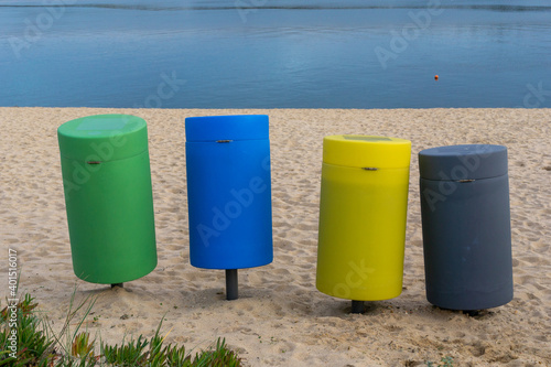 colorful recycling bins on a sandy beach