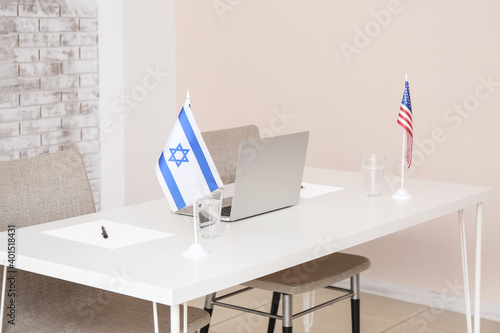 Flags of Israel and USA on table in embassy office photo