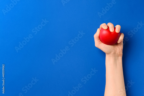 Female hand with heart on color background
