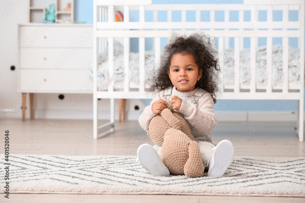 Cute African-American baby girl with toy at home Cute African-American baby girl with toy at home