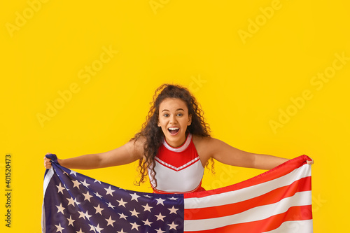 Emotional cheerleader with USA flag on color background