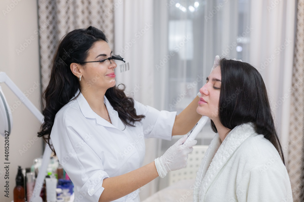 Obraz premium A client at a beautician's appointment, consultation, face shaping, preparation for upcoming procedures, visual examination of problem areas