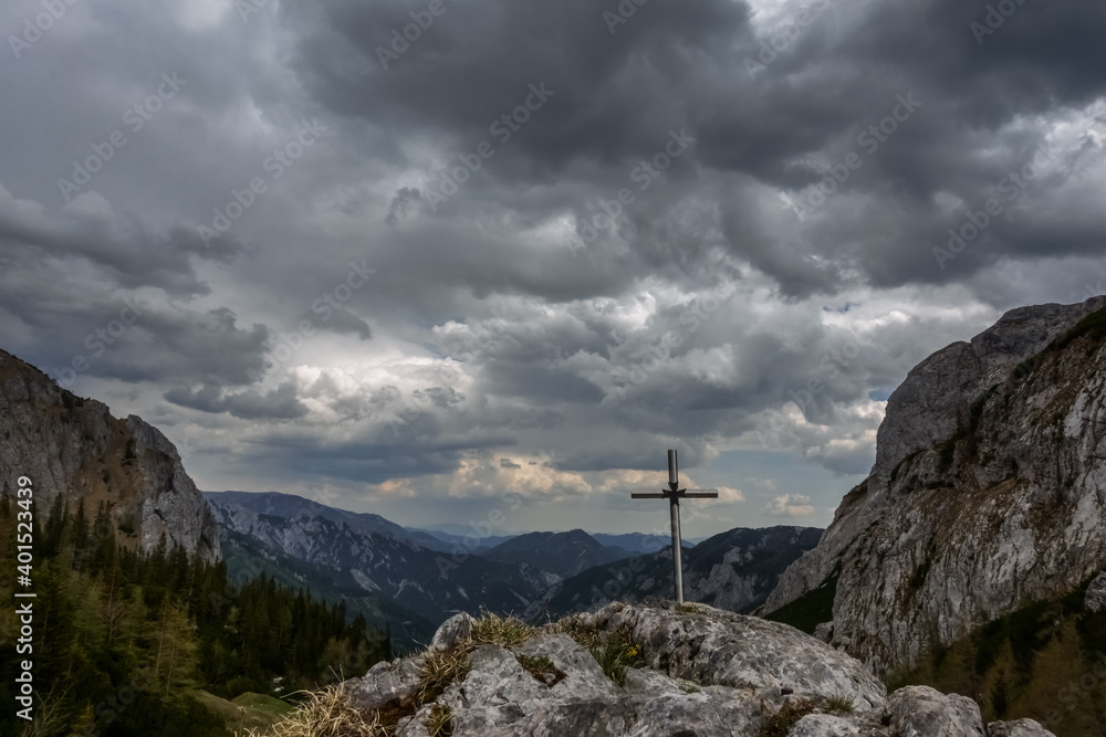 Fototapeta premium cross on a rock at the highest point of the mountain while hiking