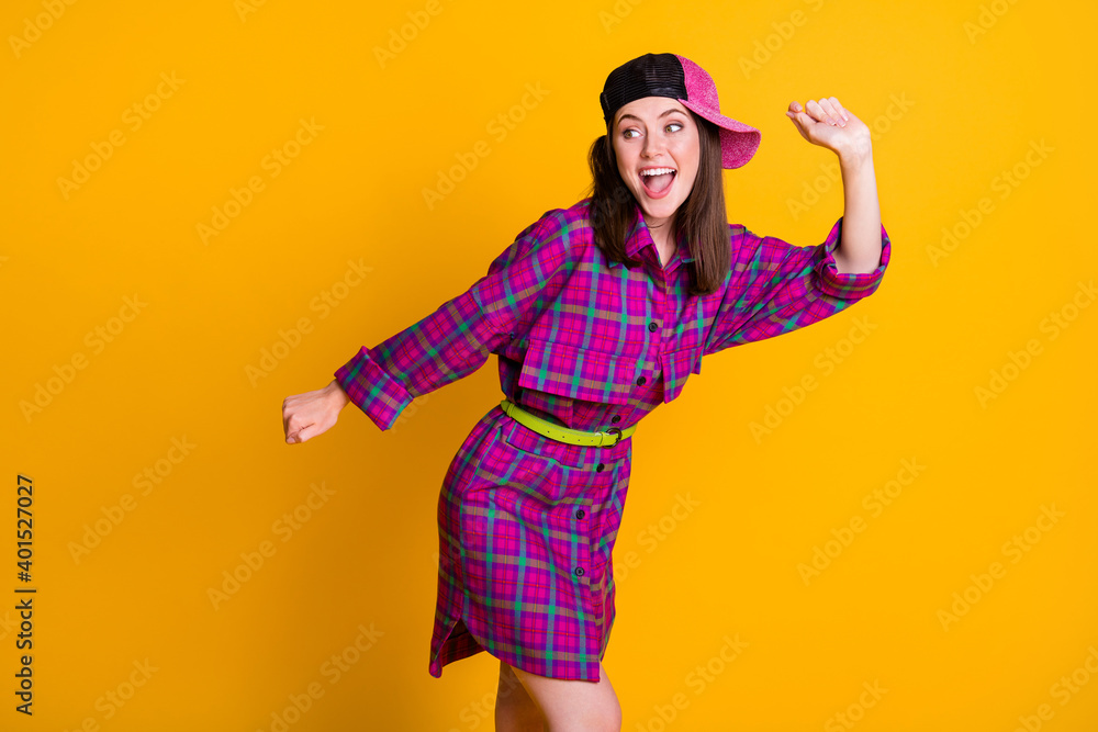 Photo of cheerful funny brunette girl dancing hands fists wear pink dress headwear isolated on yellow color background Photo of cheerful funny brunette girl dancing hands fists wear pink dress headwear isolated on yellow color background