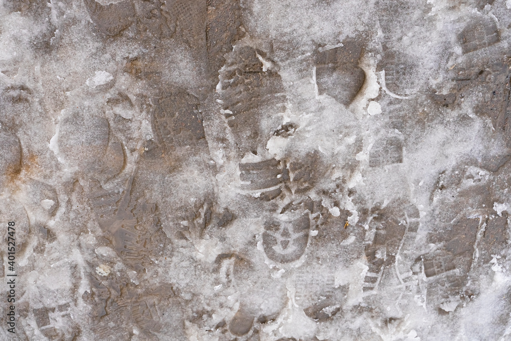 Snow melts on the asphalt. Footprints in the snow. Gray dirty snow. Melting snow texture. Thaw in winter. Winter abstraction Snow melts on the asphalt. Footprints in the snow. Gray dirty snow. Melting snow texture. Thaw in winter. Winter abstraction