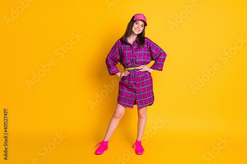 Full body portrait of satisfied young lady put hands on waist headwear isolated on bright yellow color background