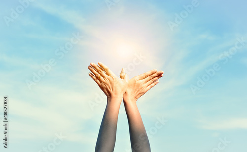 Hand symbol of freedom, Woman hand with sky background and bright light.