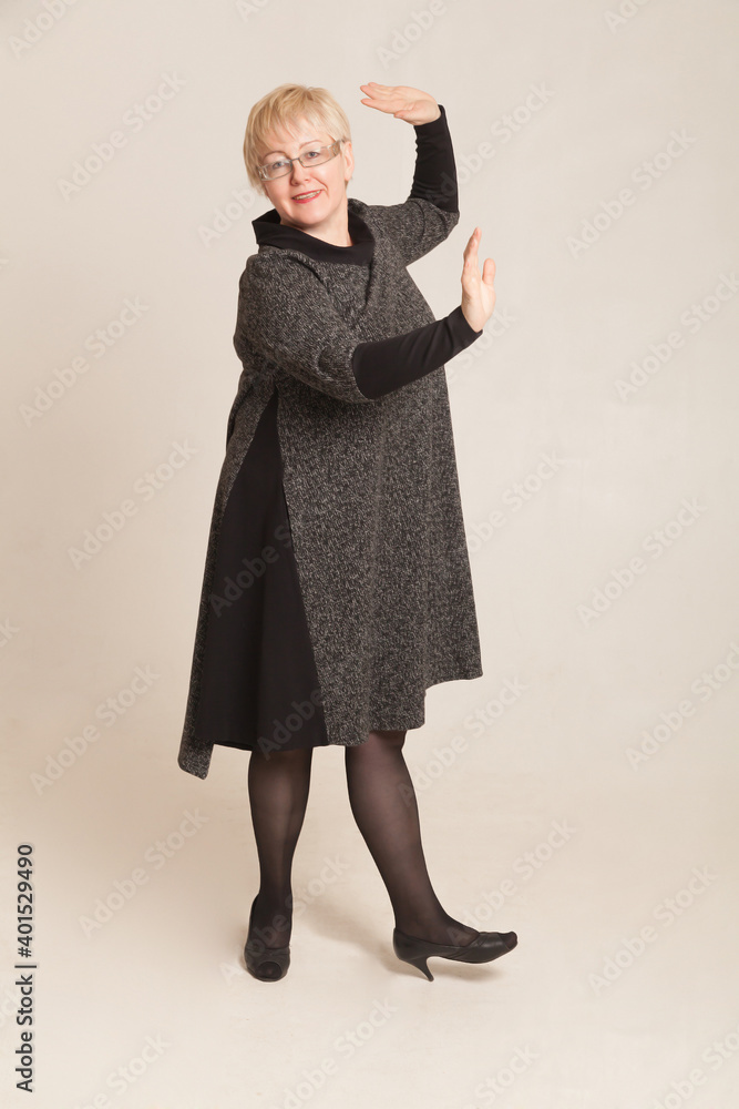 Studio portrait of blonde adult woman with short hair in gray dress