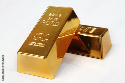 Two gold bar decorate on white table.