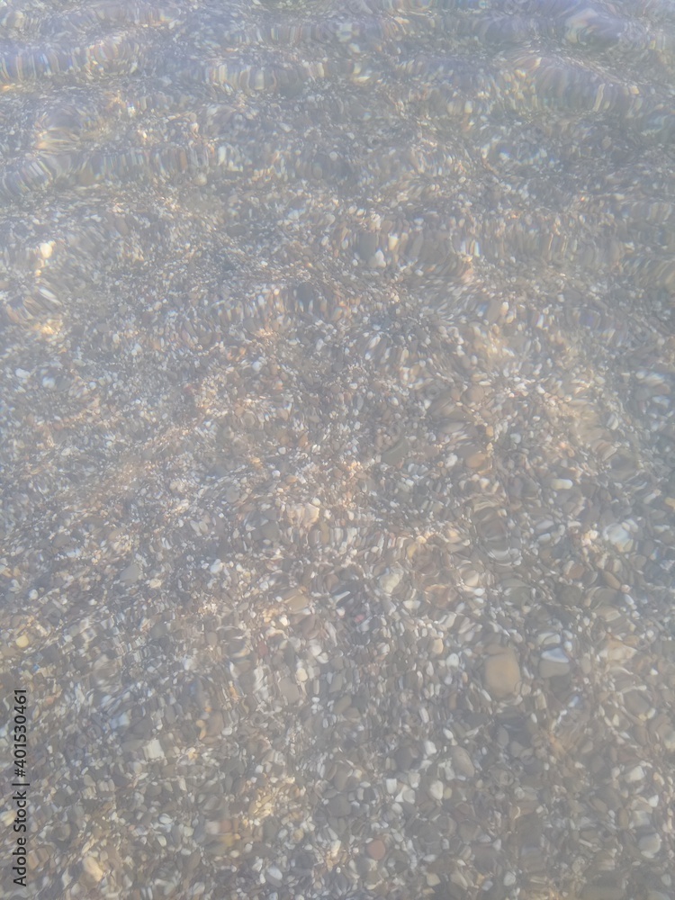 shoreline with small pebbles and water close-up. High quality photo