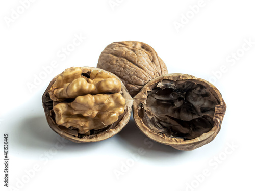 Whole wallnut, half in shell with a wallnut shell intact on the back on an isolated white background