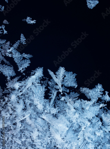 vertical winter background frame with shiny white crystals of snowflakes and ...
