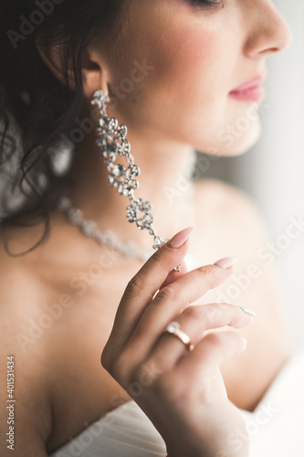 Portrait of beautiful bride with fashion veil at wedding morning