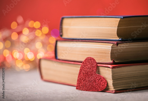 Stack of books and red heart. Romantic background with the book