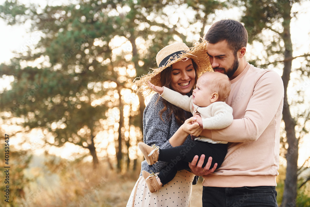 Unity of the people. Happy family of mother, family and little baby rests outdoors. Beautiful sunny autumn nature Unity of the people. Happy family of mother, family and little baby rests outdoors. Beautiful sunny autumn nature