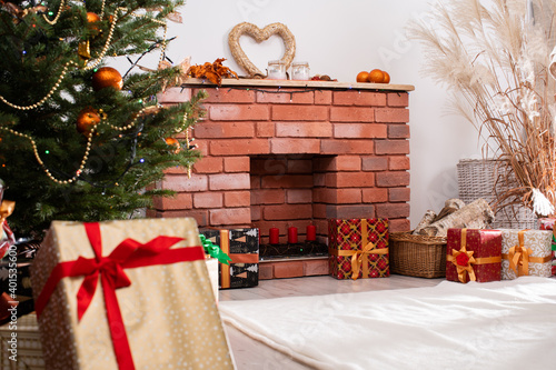 Christmas tree decorated with golden baubles and a chain. Christian holidays. A warmly decorated living room at home.