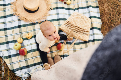 Top view. Having picnic. Young mother with her little baby rests outdoors at autumn season