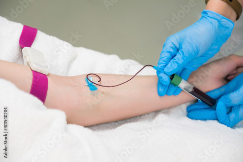 Laboratory worker doctor takes a blood sample for analysis  hand closeup. Blood sampling in the laboratory. Taking a blood in cosmetology clinic before PRP therapy procedure.