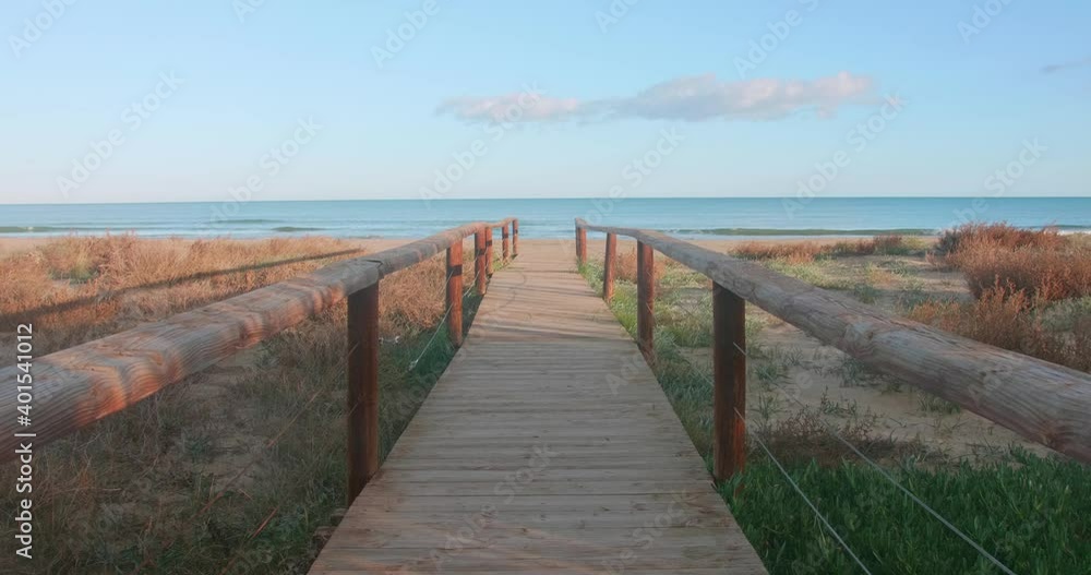 Wooden boardwalk leading to a beautiful beach. Paradise atmosphere near the sea. Wooden boardwalk leading to a beautiful beach. Paradise atmosphere near the sea.