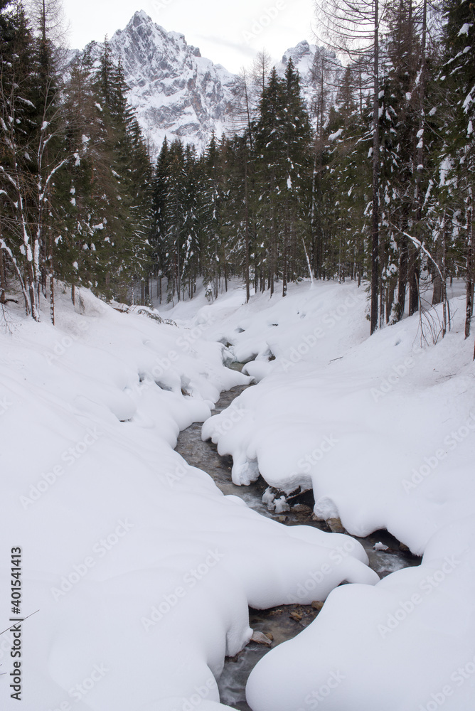 uno splendido paesaggio montano innevato, un fiume scorre i mezzo a montagne di neve, la magia dell'inverno in montagna uno splendido paesaggio montano innevato, un fiume scorre i mezzo a montagne di neve, la magia dell'inverno in montagna