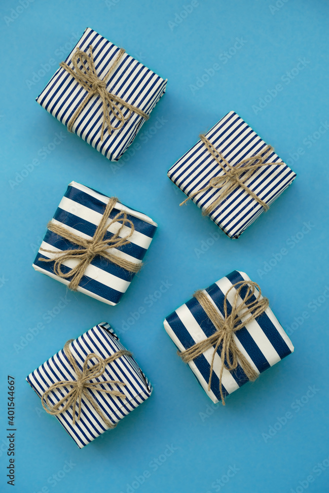 Fototapeta premium Holiday gifts decorated with striped paper on a blue background
