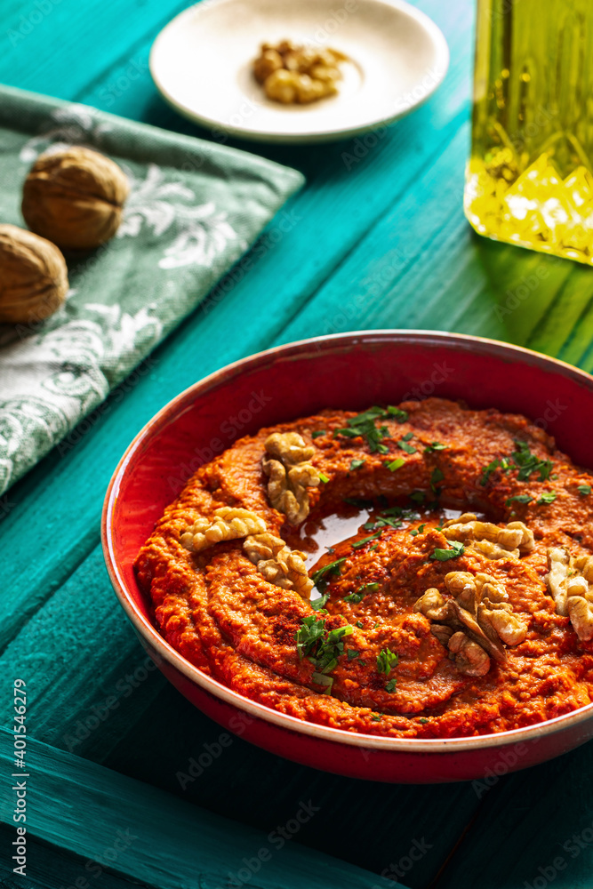 Roasted red bell pepper spread in a red bowl with various ingredients Roasted red bell pepper spread in a red bowl with various ingredients