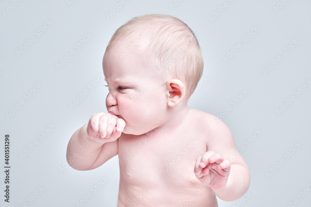 Portrait of a toddler boy with a displeased face, teething, feeling pain Portrait of a toddler boy with a displeased face, teething, feeling pain