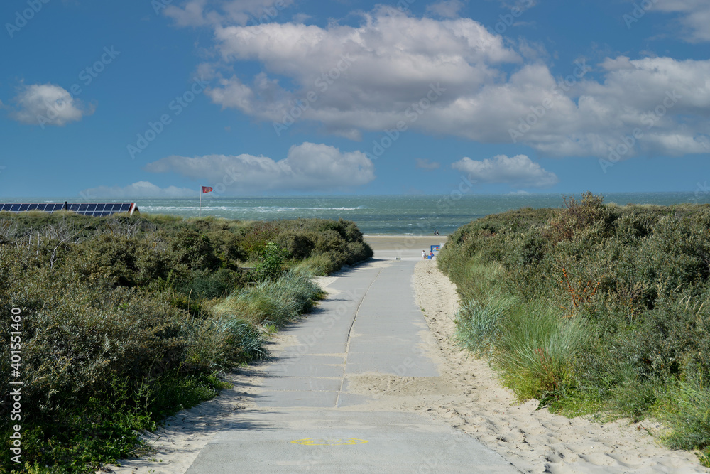 Footpath between the dunes to the beach with the sea