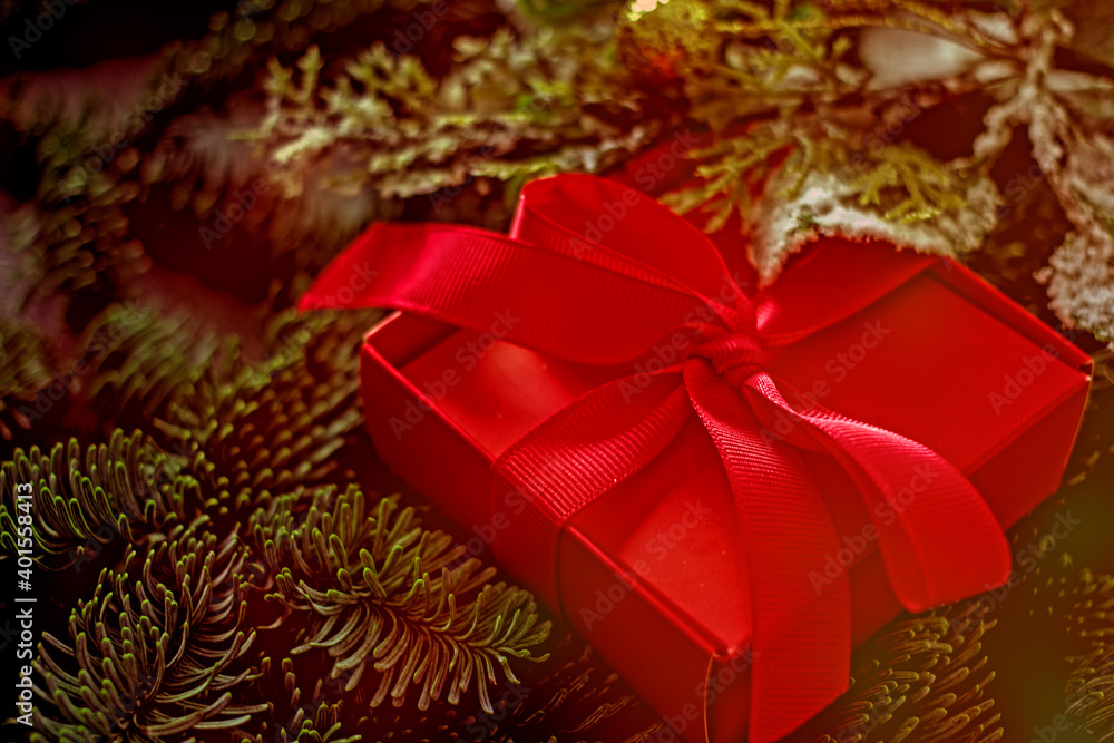 Pink gift box with a bow in the fir branches. Festive background with a gift. Pink gift box with a bow in the fir branches. Festive background with a gift.